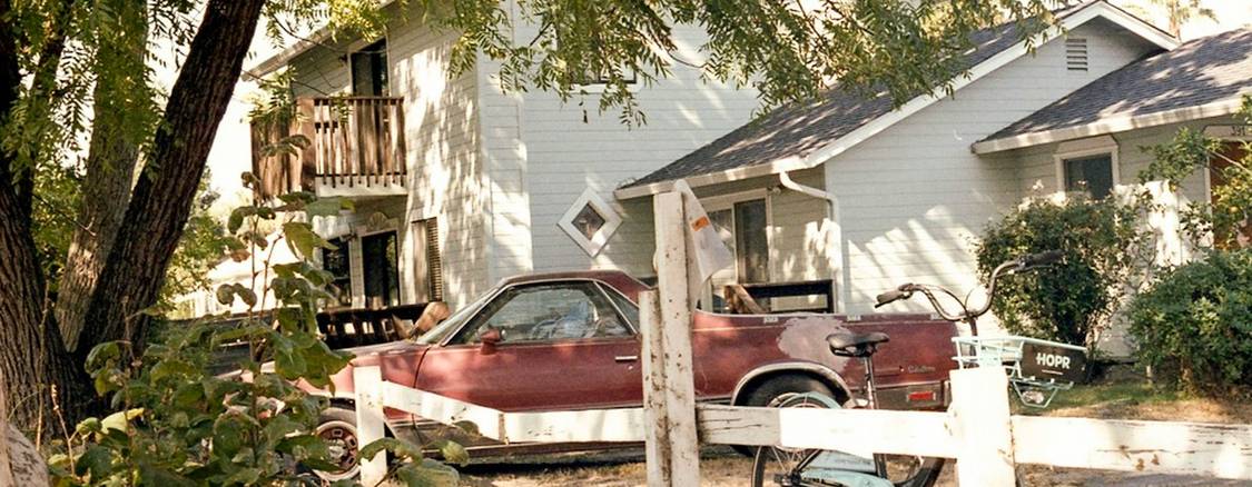 A car and a house together, or insurance documents on a desk. Illustrates the concept of bundling auto and home insurance in Texas.