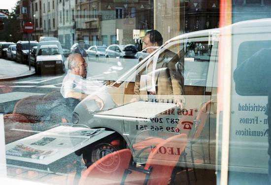 A group of people negotiating car insurance rates with an agent, reviewing documents at a table