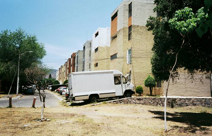 A Texas neighborhood street with a car parked and moving boxes visible, representing a move and address change for auto insurance