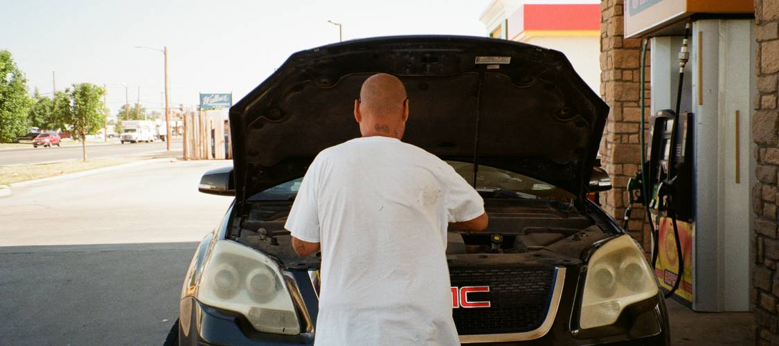 A person receiving car keys at a dealership, symbolizing new car delivery and insurance protection in Texas